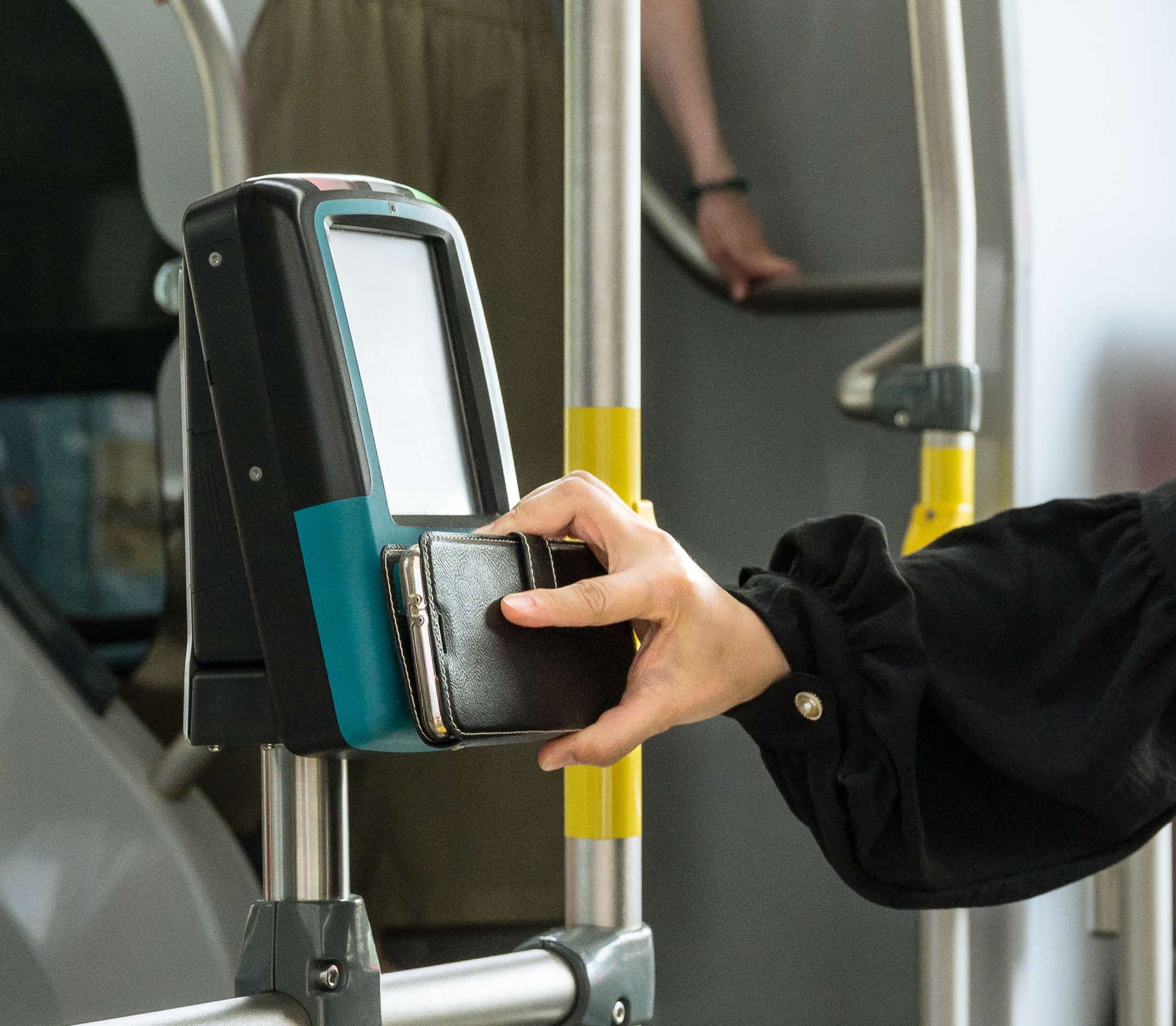 A woman's hand tapping out while alighting the bus